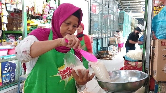 Pedagang di Pasar Kranggan, Mariatun tengah menimbang gula pasir saat ditemui, Rabu (29/11/2023).