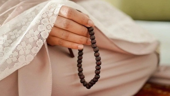 Ilustrasi wanita berzikir dan membaca sholawat Munjiyat setelah shalat