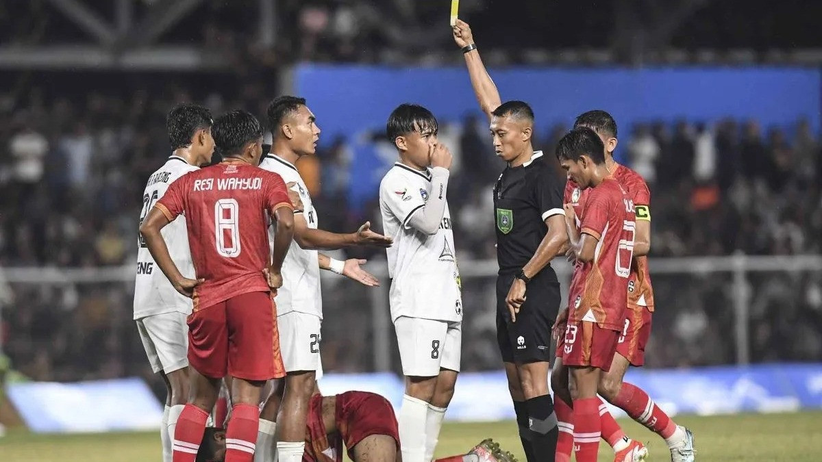 Wasit Eko Agus Sugiharto (kedua kanan) memberikan kartu kuning kepada pesepak bola Sulawesi Tengah Ichansyah