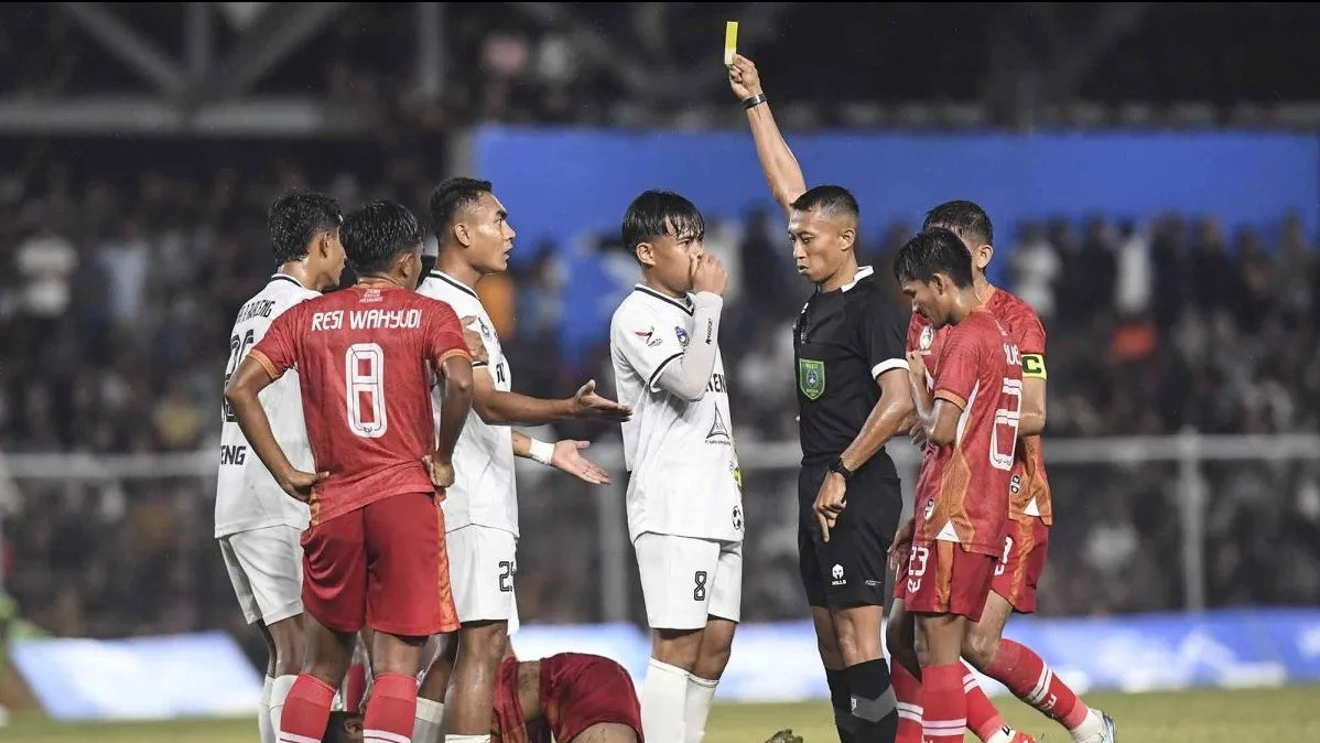 Wasit Eko Agus Sugiharto (kedua kanan) memberikan kartu kuning kepada pesepak bola Sulawesi Tengah Ichansyah (ketiga kiri) saat melawan tim Aceh pada pertandingan babak 8 besar PON XXI Aceh-Sumut 202