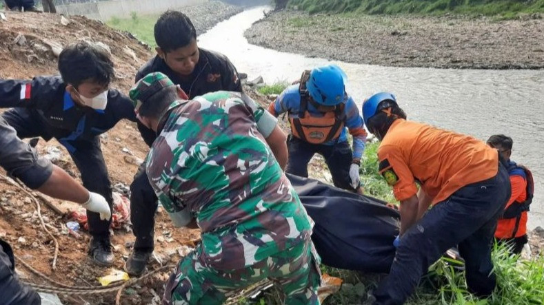 Sejumlah petugas BPBD Kota Bekasi dan polisi berdiri dengan latar depan kantong-kantong berisi tujuh jenazah laki laki yang ditemukan mengambang di Kali Bekasi, Pondok Gede Permai, Jatiasih, Kota Bekasi, Minggu (22/9/2024).