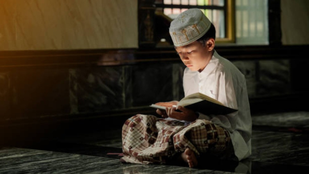 Ilustrasi anak kecil membaca surat Al Quran setelah shalat Tahajud