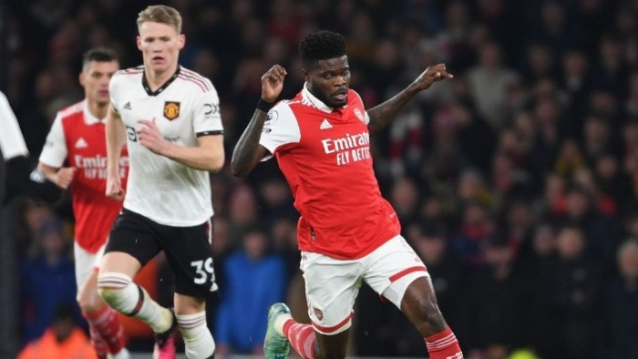 Gelandang bertahan Arsenal, Thomas Partey saat menggiring bola melewati pemain MU