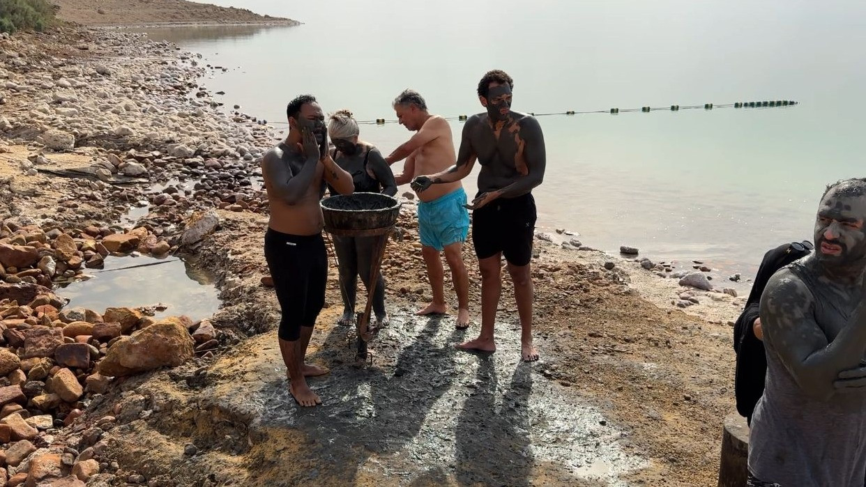 Wisatawan luluran menggunakan lumpur Laut Mati yang dipercaya baik untuk kulit.