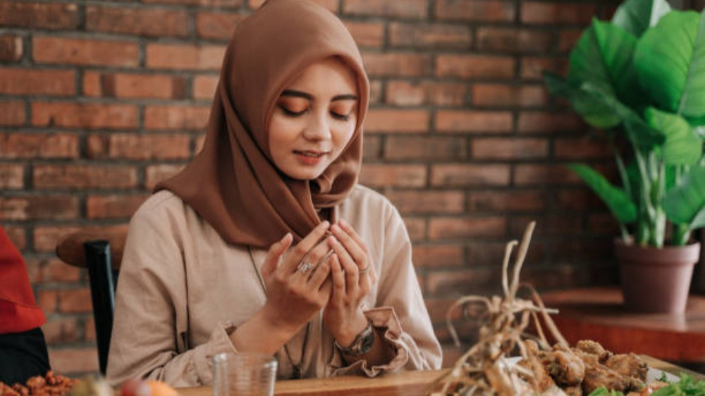 Ilustrasi wanita Muslimah membaca doa buka puasa Ramadhan setelah dengar adzan Maghrib