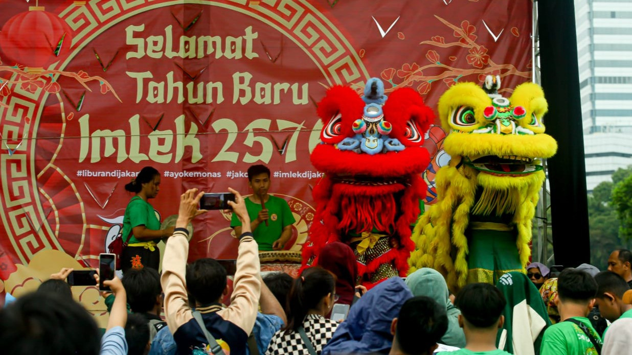 Para wisatawan pengunjung Monas menyaksikan pertunjukan Barongsai, dalam rangka menyambut hari raya Imlek Tahun 2025, di Kawasan Monas, Jakarta Pusat, Selasa (28/1/2025)