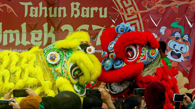 Para wisatawan pengunjung Monas menyaksikan pertunjukan Barongsai, dalam rangka menyambut hari raya Imlek Tahun 2025, di Kawasan Monas, Jakarta Pusat, Selasa (28/1/2025)