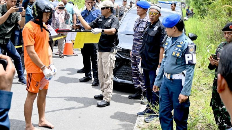 Tersangka, oknum TNI AL Kelasi Satu Jumran memperagakan adegan pembunuhan jurnalis saat rekonstruksi 33 adegan di TKP, Jalan Trans Gunung Kupang, Kelurahan/Kecamatan Cempaka, Kota Banjarbaru, Kalimantan Selatan, Sabtu (5/4/2025).